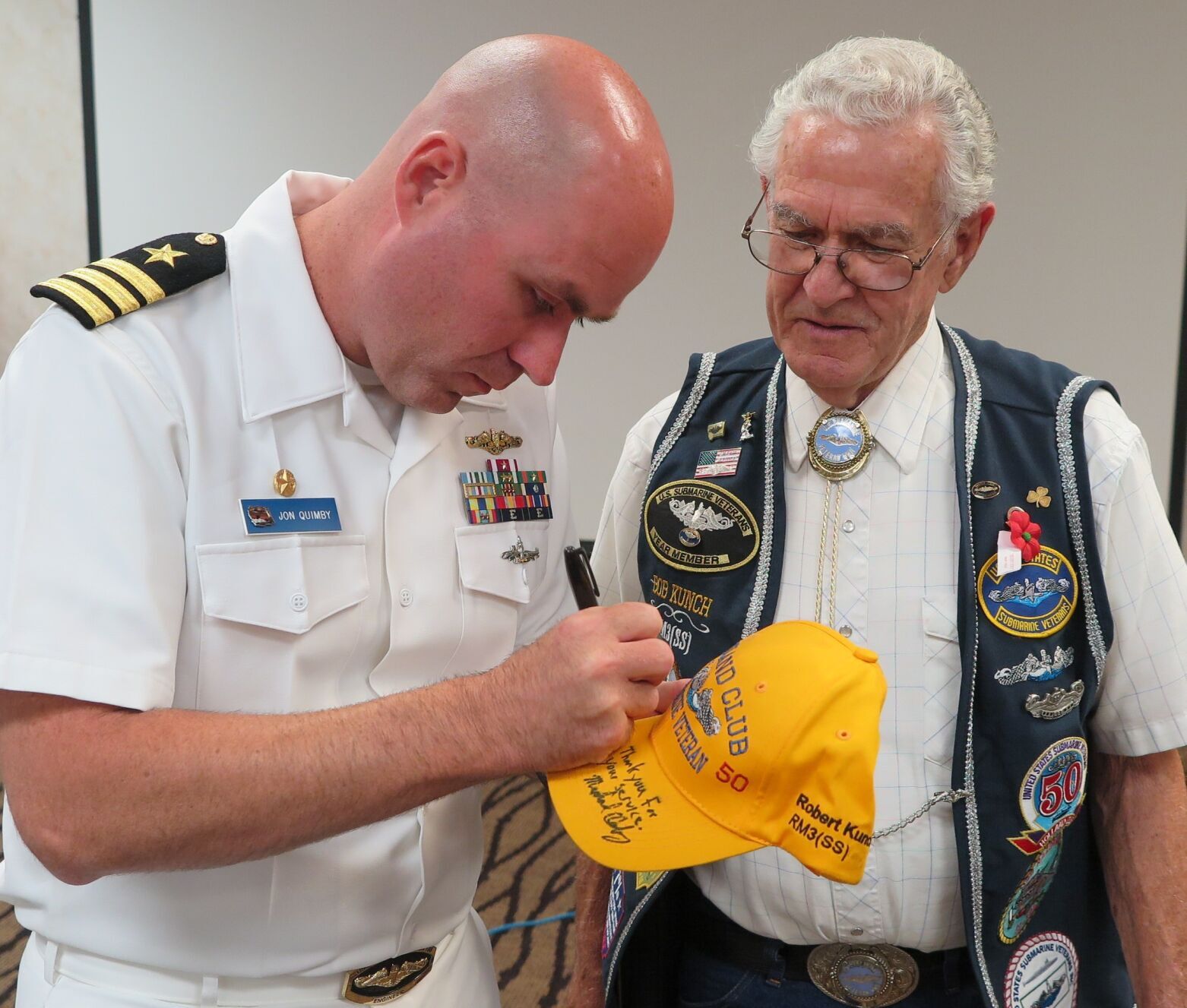 Cmdr. Jon Quimby signs a “Holland Club” hat